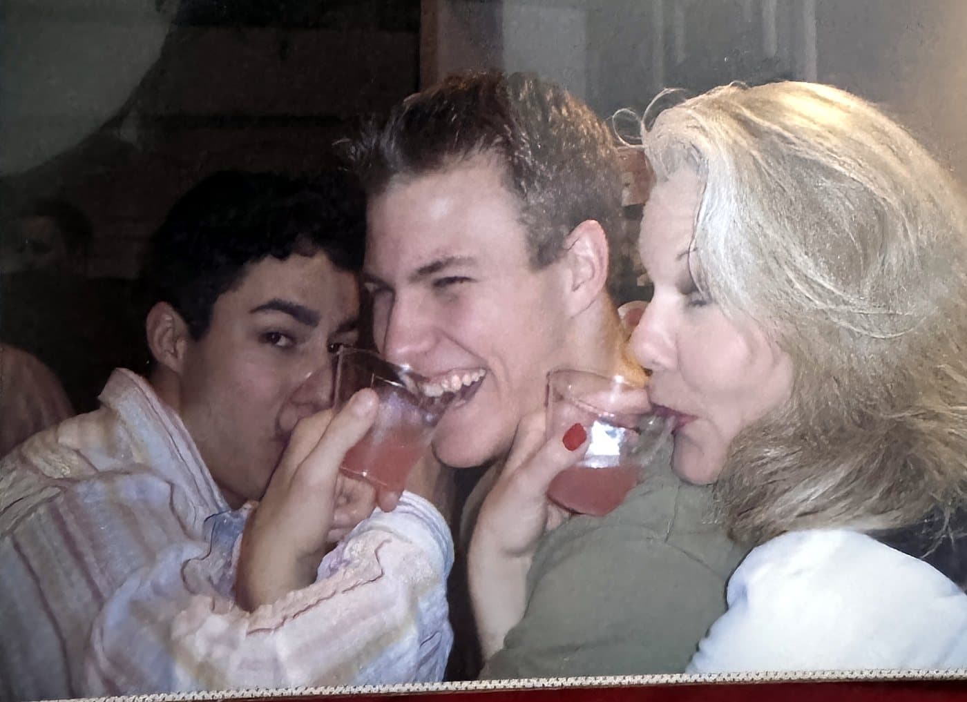Eve Hess laughing and raising a glass with Isaac and another friend