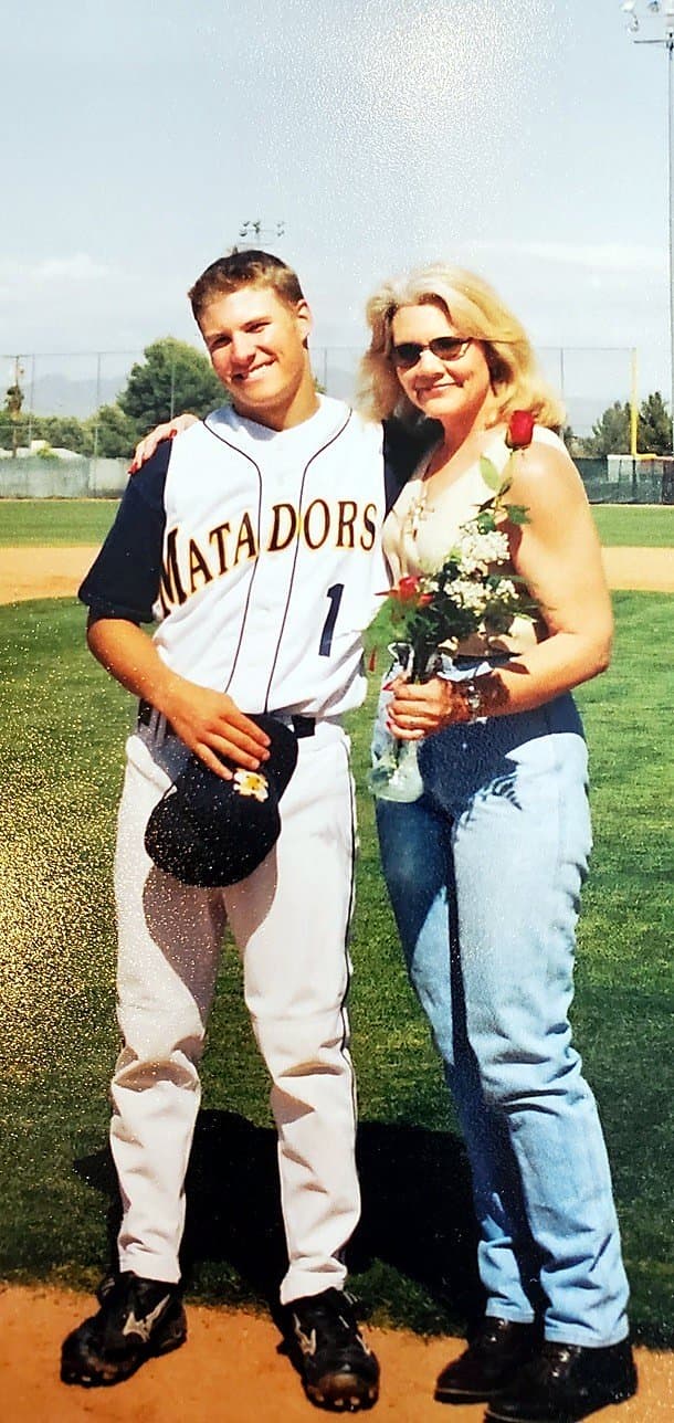 Isaac Hess in his Shadow Mountain Matadors number 1 uniform beside his mom, Eve, who is holding flowers