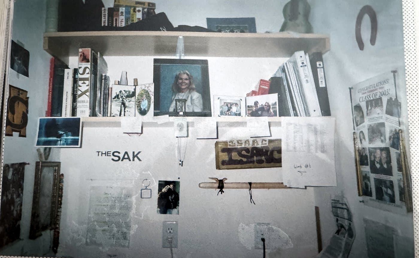 Isaac Hess's desk and wall at the Seasons apartment in Tucson, with his mom's photo on the shelf and her graduation poster on the wall