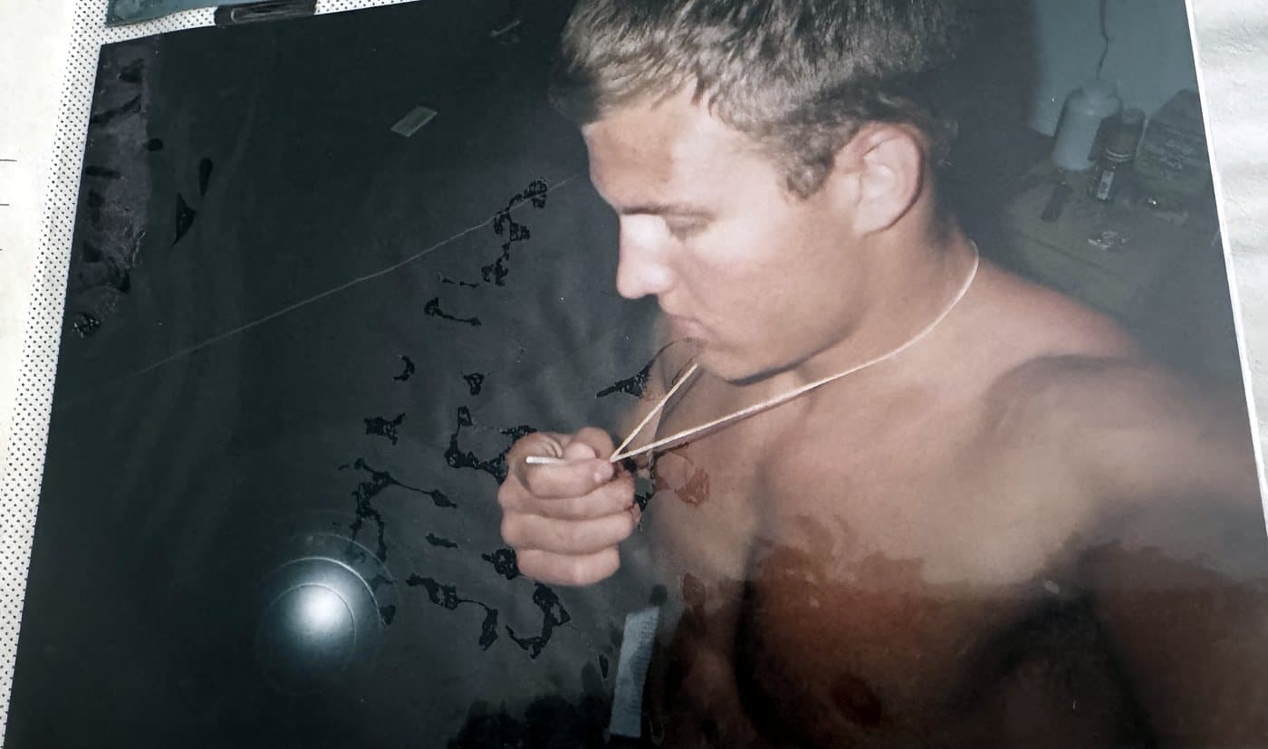 Isaac Hess kissing the small baseball bat pendant on his necklace
